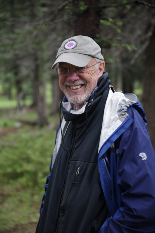 Robert Birkby stands in a forest for his portrait.