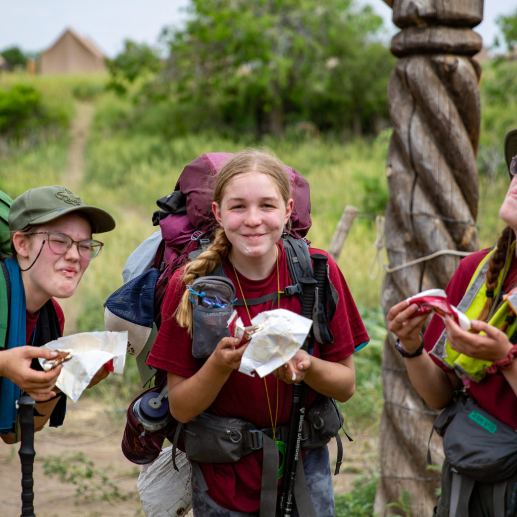 (from right to left) Rin "firefly" Leonard, Marrisa "Brad" Fugitt, and Loralei "Skittles" Dawson from 612-BB enjoy some ice cream at the "You Made it Sign" after a 10 mile hike into base camp!