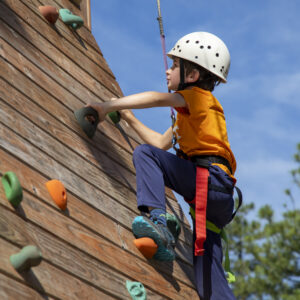 A member of the Trappers group climbs up the side of the climbing wall at the COPE course as a part of programming at the Philmont Training Center in Cimarron, N.M. on July 13, 2022.
