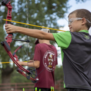 A PTC family adventure camp participant takes a shot at the target at the archery range at the PTC Shooting Sports Range in Cimarron, N.M., on July 14, 2022.