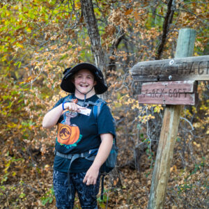 Autumn Family Adventure participant Daegen poses with the T-Rex Track sign at Philmont Scout Ranch in Cimarron, N.M. on October 12, 2024.
